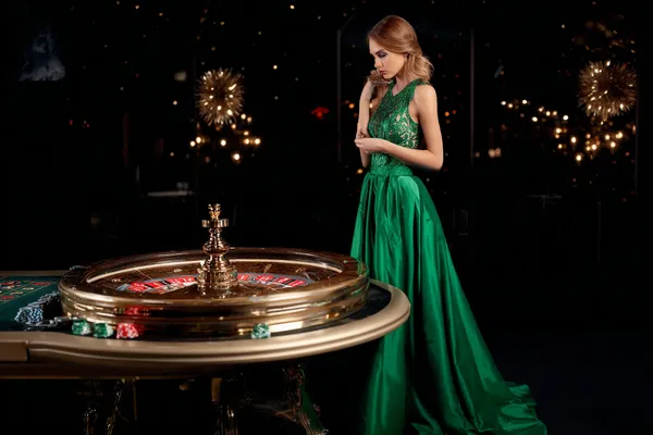 A professional dealer in a tuxedo greeting players at the roulette table, symbolizing the authentic live casino feel at KM787.